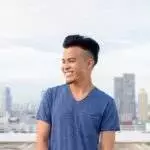Happy young handsome multi ethnic man thinking against view of the city